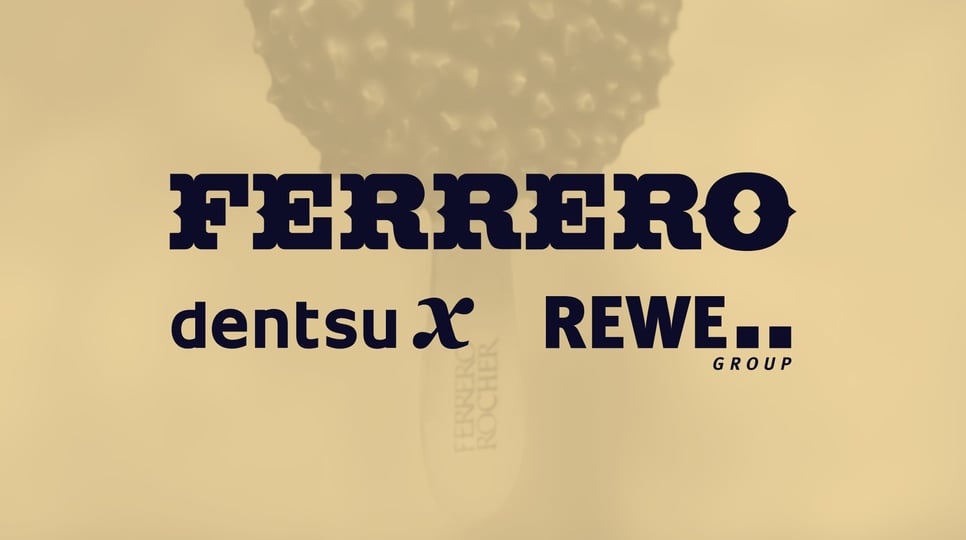 Image shows a Ferrero Rocher ice cream bar. Ferrero Rocher, Dentsu X, Rewe Group logos are pictured in the top left corner of the image