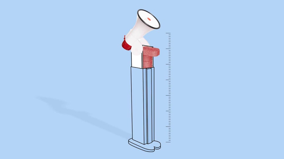 A red pill dispenser topped with a blow horn stands beside measuring lines.